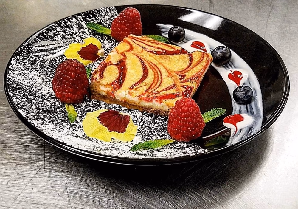 Plated dessert with berries and edible flowers