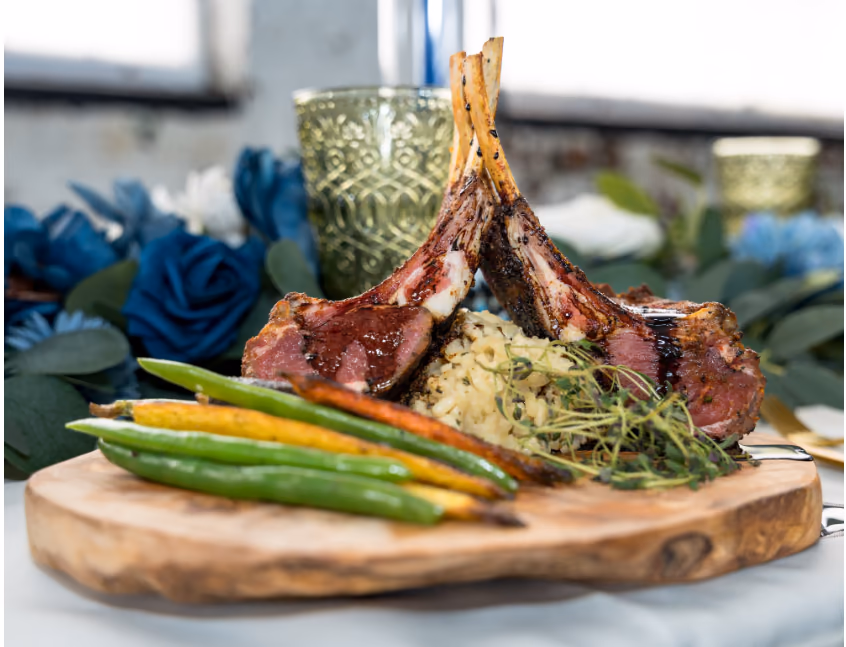 Lamb rack with colorful vegetables and blue roses